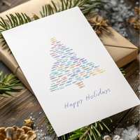 Christmas card with colorful tree design and 'Happy Holidays' text, surrounded by festive decorations on a wooden surface.